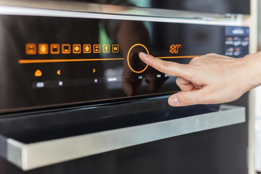 Femme utilisant le panneau de sa cuisinière électrique