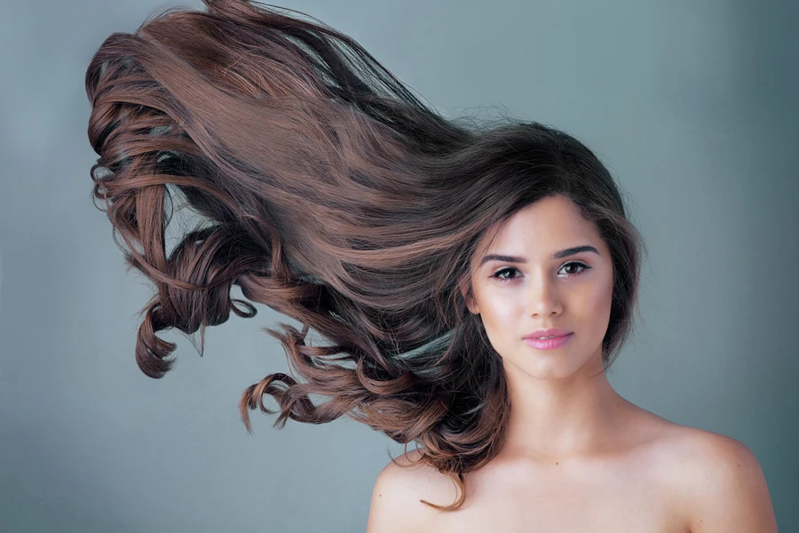 Woman with long brown hair blowing in the wind