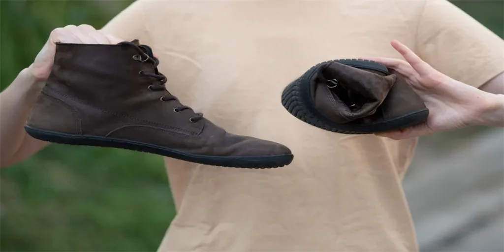 Les mains des femmes tiennent des chaussures marron anatomiques ou orthopédiques tordues