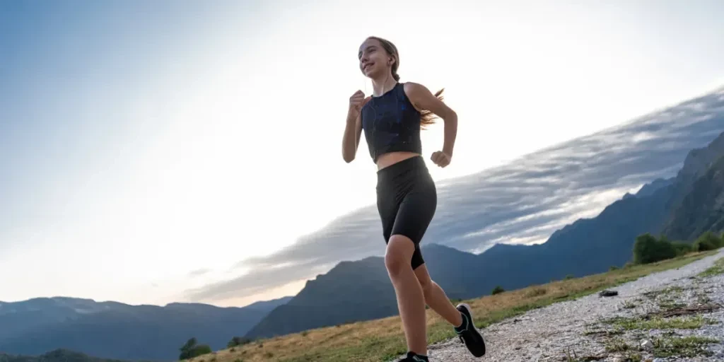 Junges Mädchen beim Sunset Trail Running in den europäischen Alpen