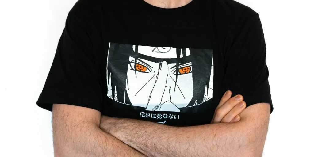 Jovem com boné preto e camisa de anime, usando AirPods contra um fundo branco por Andrea De Santis