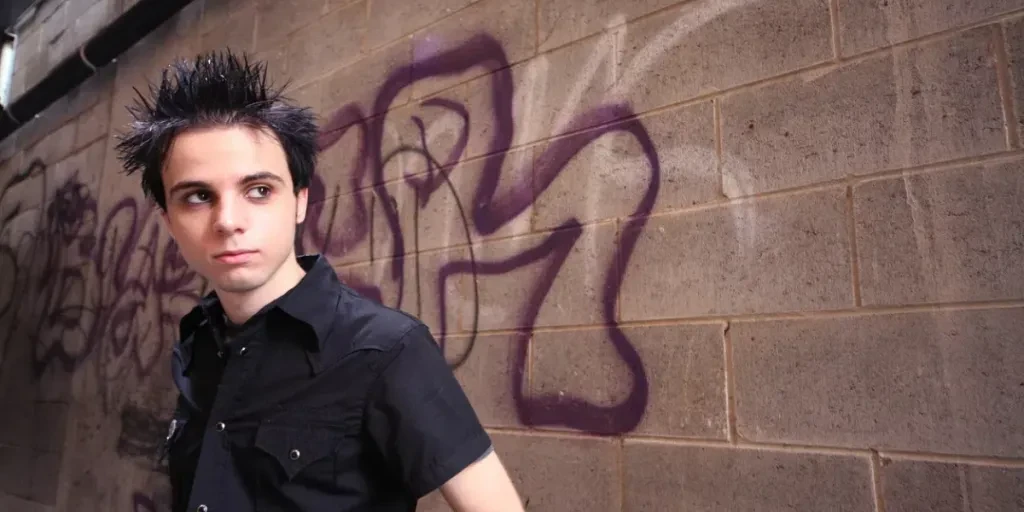 Young man in front of grunge wall.