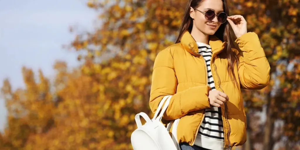 Jeune femme avec un sac à dos élégant le jour de l'automne, espace pour le texte