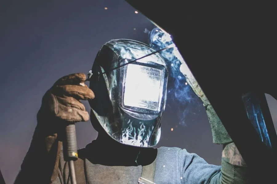 A man concentrates as he uses a TIG welder