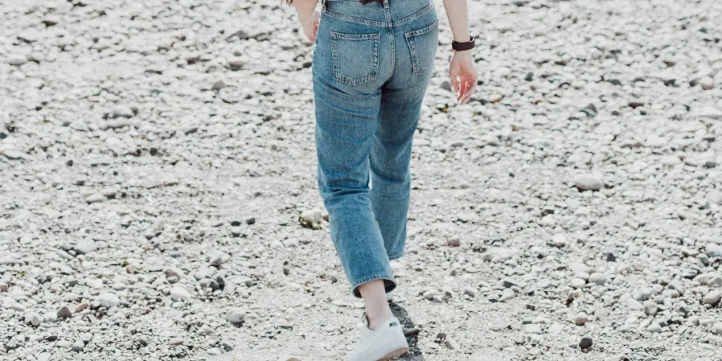 a woman walking across a sandy beach next to the ocean by Priscilla Du Preez 🇨🇦