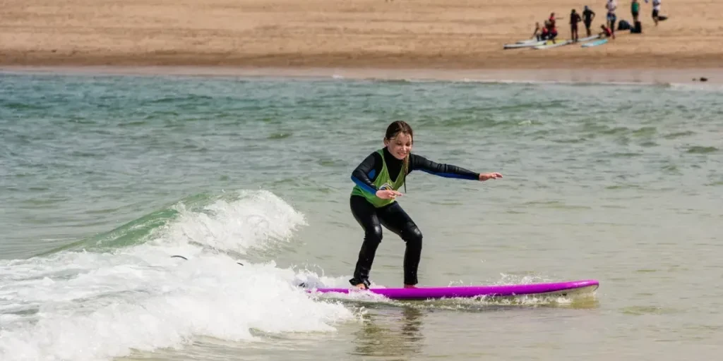 cute smiling girl riding a small wave