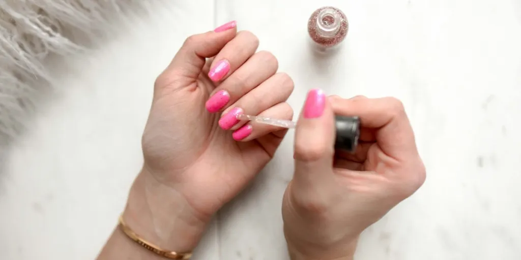 menina aplicando esmalte em gel rosa