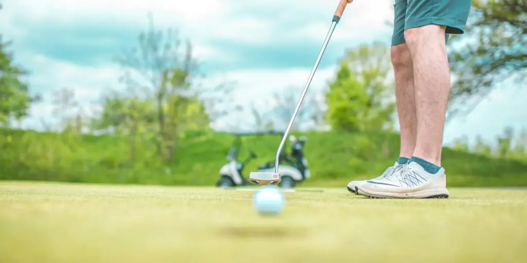 homme jouant au golf sous un ciel bleu pendant la journée