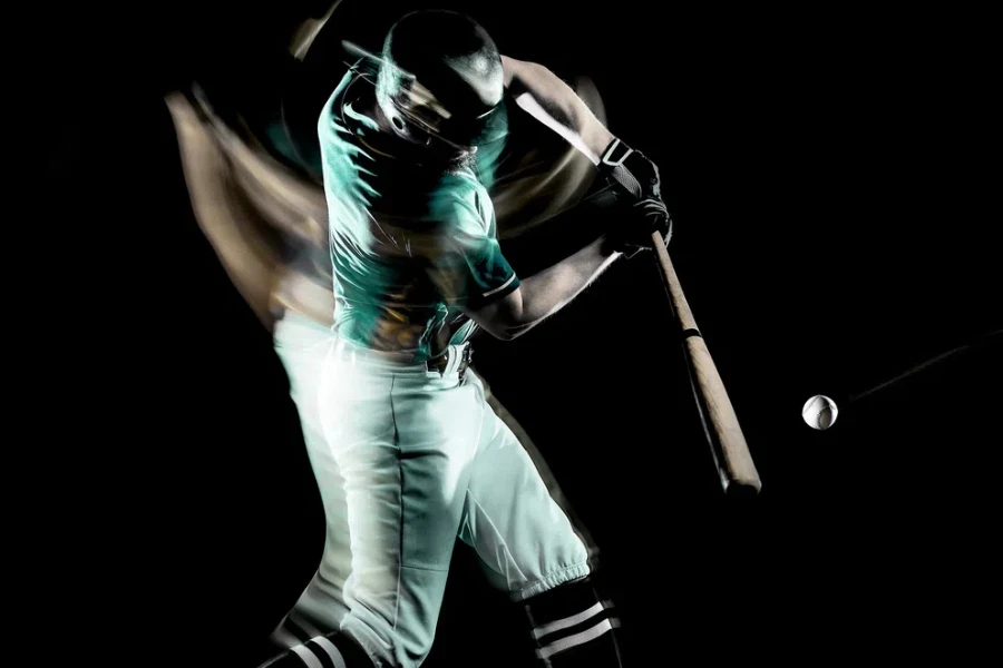 one caucasian baseball player man studio shot isolated on black background with light painting speed effect