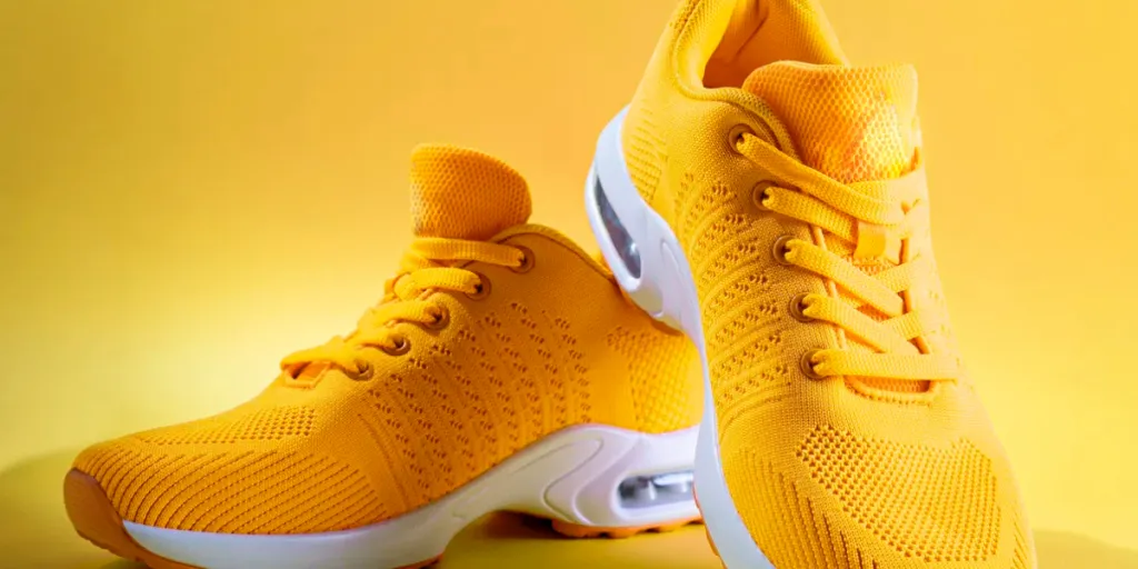 pair of yellow sneakers on yellow background