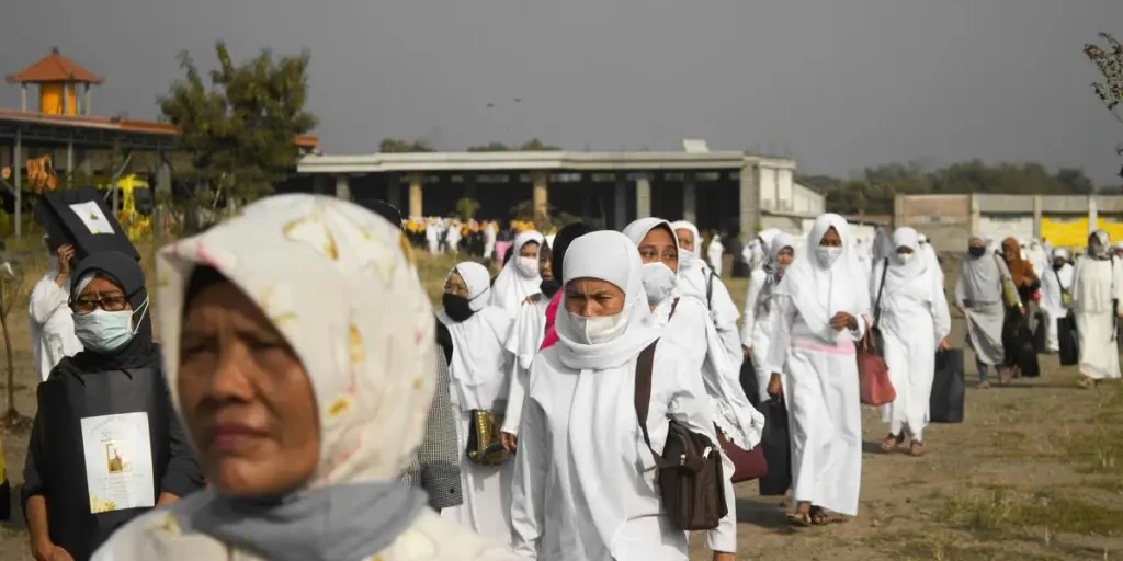 mensen in witte hijab staan ​​overdag op een bruin veld