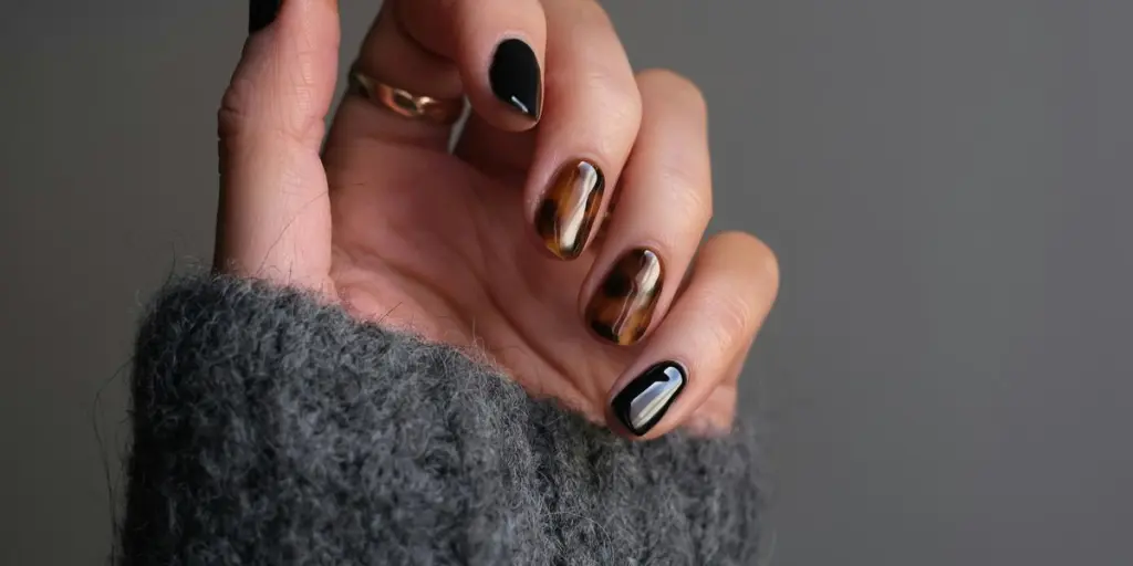 person wearing silver ring with black manicure