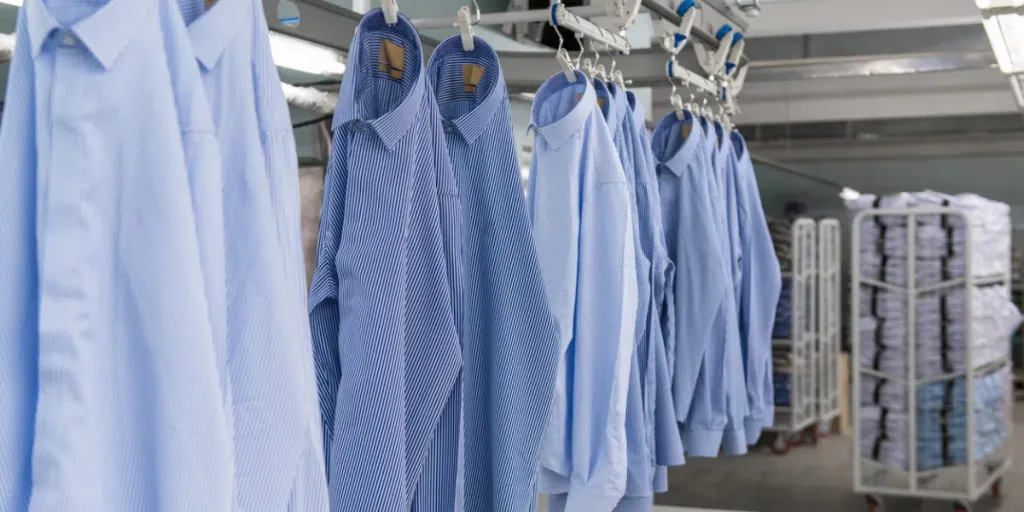 sewn new shirts hang on hangers in the textile factory workshop