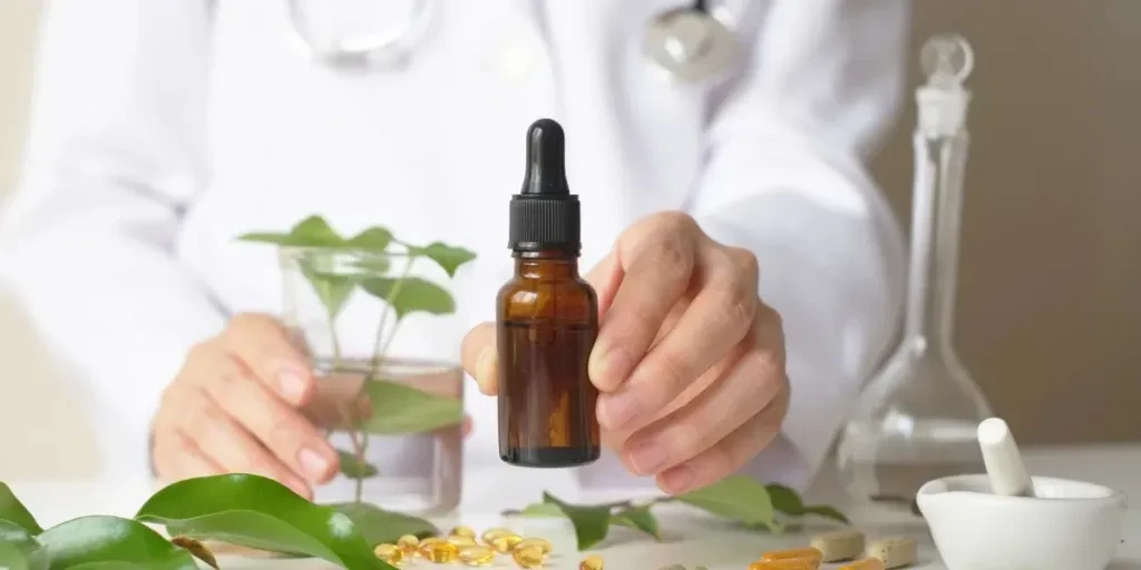 El científico o el médico elaboran medicamentos a base de hierbas en el laboratorio sobre la mesa.