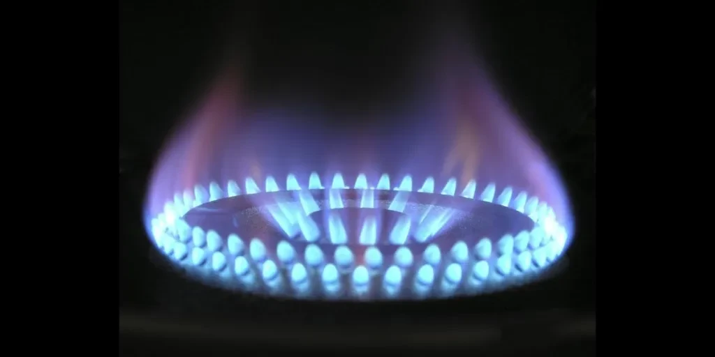 Api biru bercahaya menyala dari dapur gas