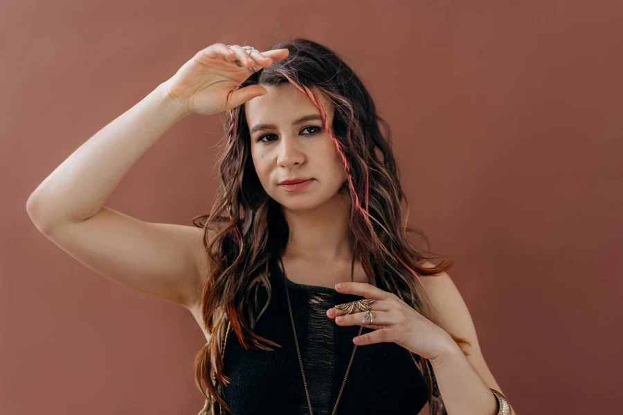 A serene portrait of a young woman with flowing hair and bohemian accessories, posing gracefully