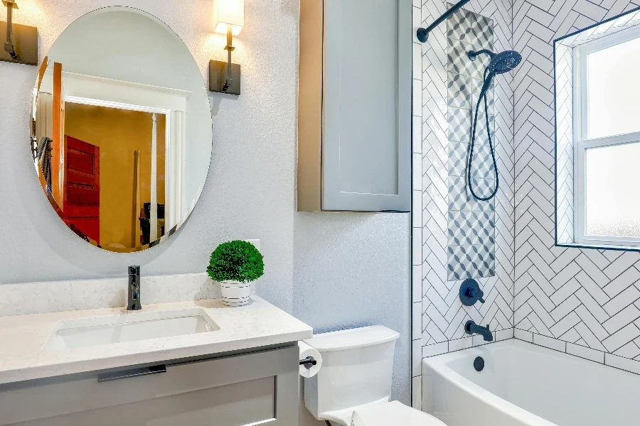 An oval mirror near a bathtub with shower