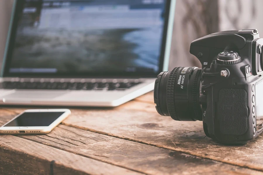 Appareil photo reflex numérique noir sur une surface en bois beige