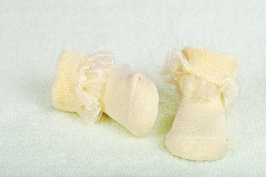 Cream color baby socks with intricate ruffle detailing