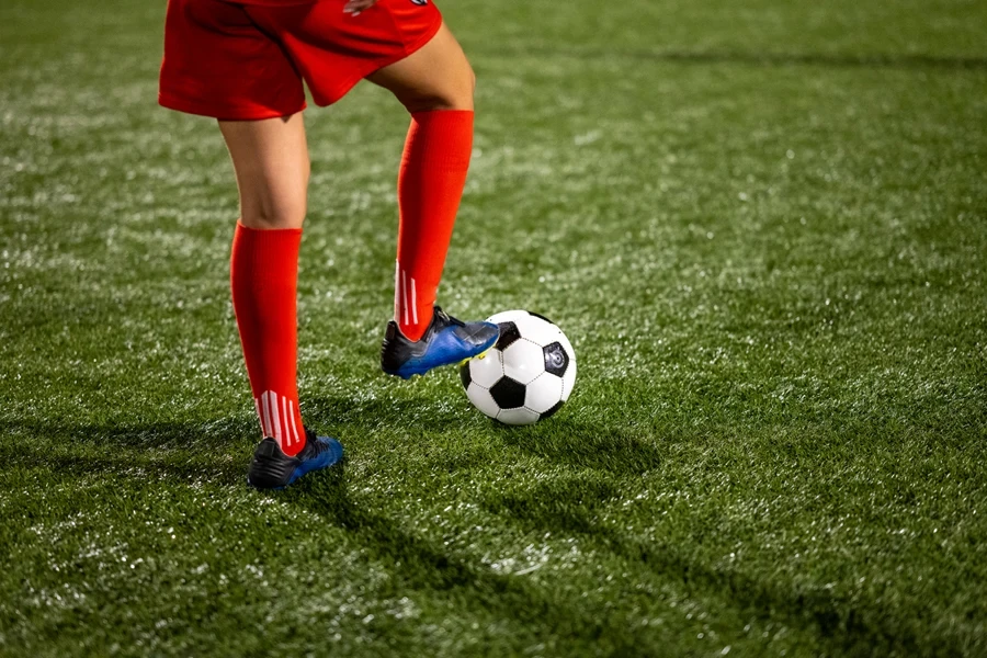 Football player wearing red grip socks and navy blue shoes