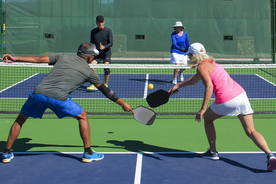 Four people playing pickleball outdoors wearing moisture-wicking socks