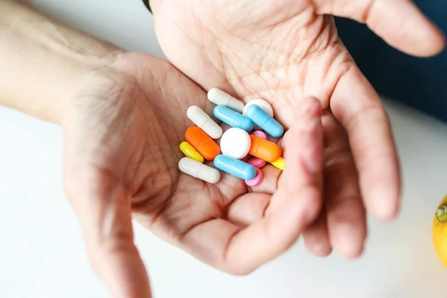 Hands of a person holding multiple pills