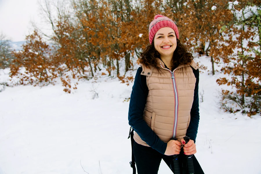 Lady in pink hat wearing a beige corduroy puffer vest