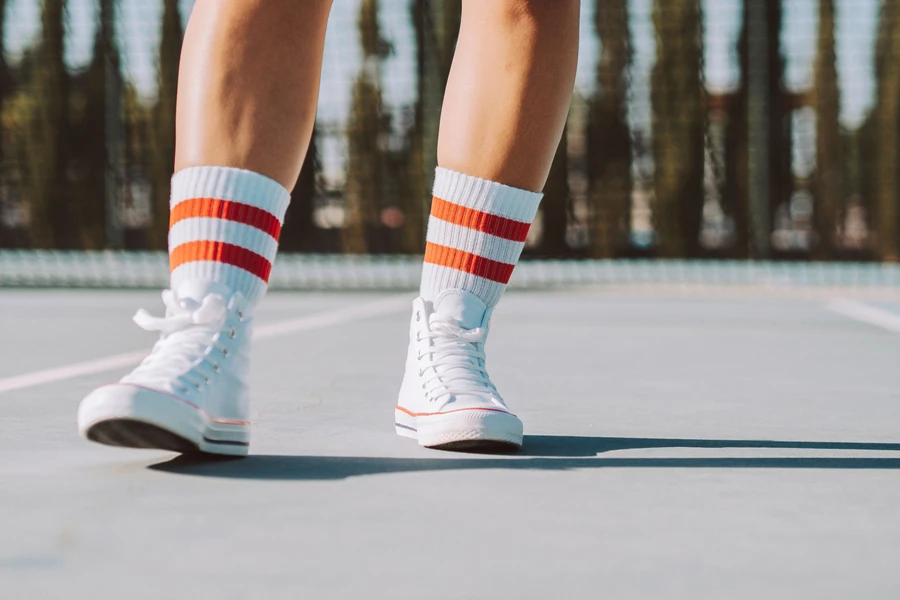 Man wearing orange striped socks on court during the day