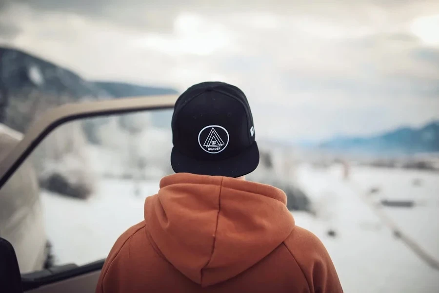 Man with his back turned in a black five-panel hat