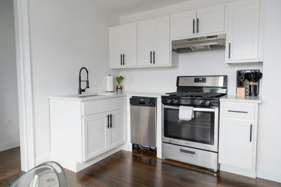 Modern kitchen with white cabinets and a silver stove