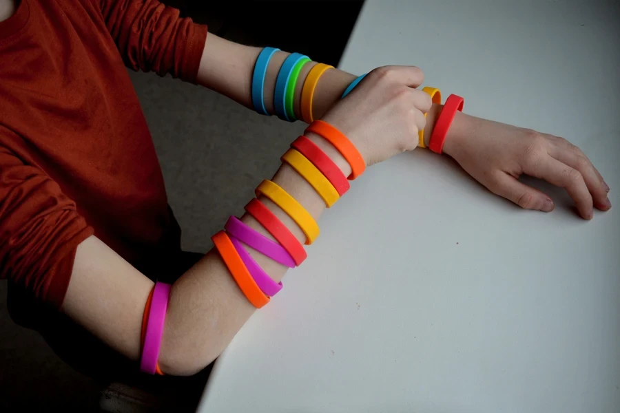 Person wearing multiple silicone bracelets