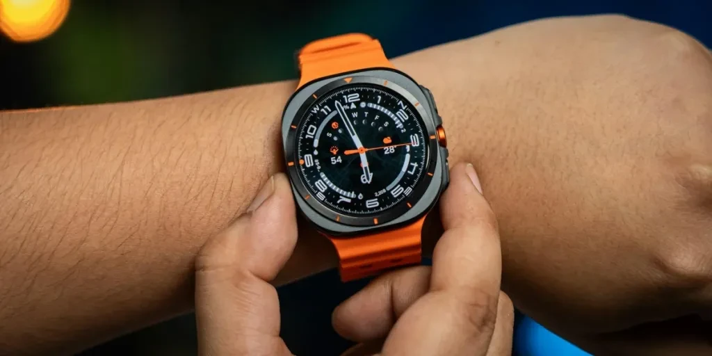 Samsung watch on a wrist with orange strap