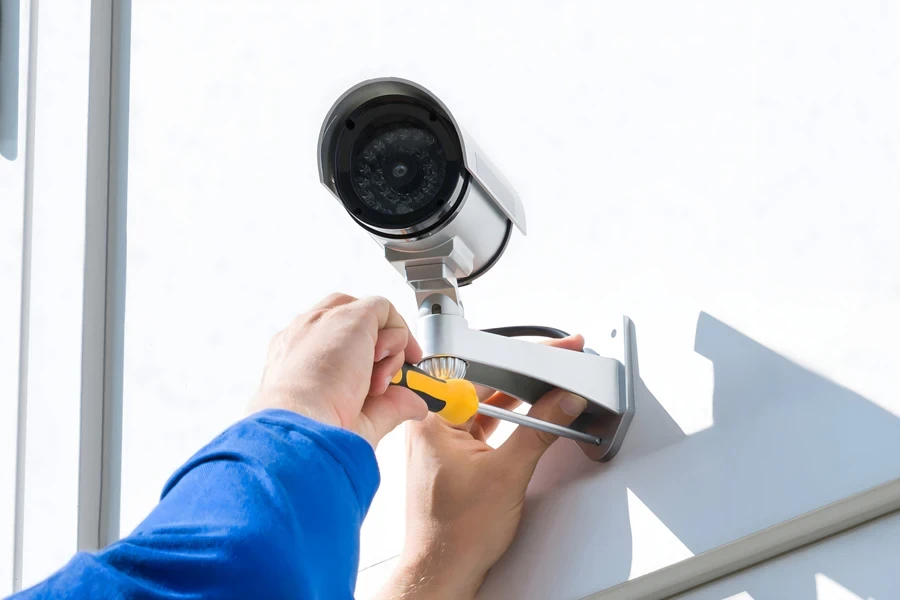 Technician installing a wireless CCTV camera on a wall