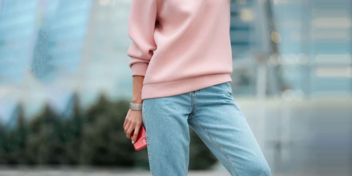 Woman in a pink sweat-shirt and straight-leg jeans