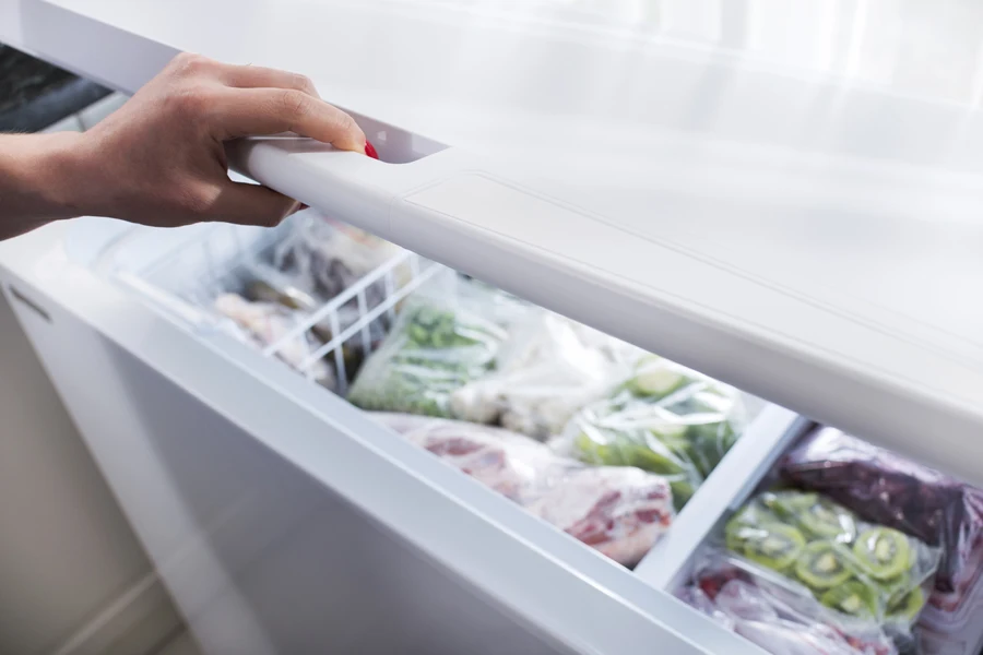 Woman opening her chest freezer door