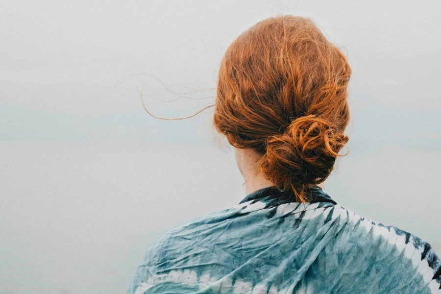 Mujer pelirroja mirando al cielo