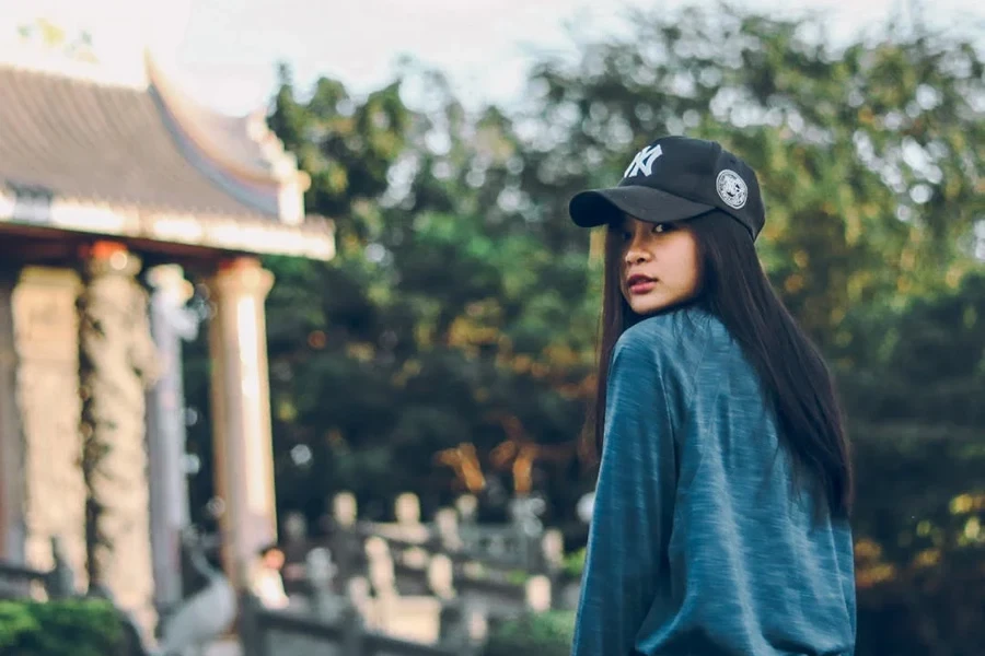 Woman rocking a sweater and five-panel cap