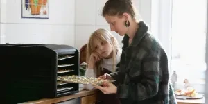 Woman using a food dehydrator with her kid