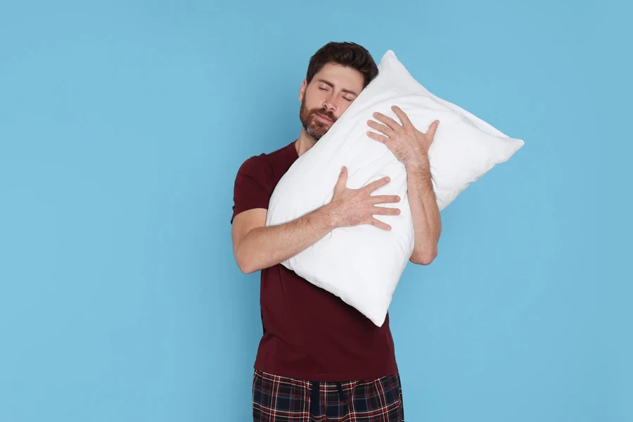 Young male hugging a fresh pillow