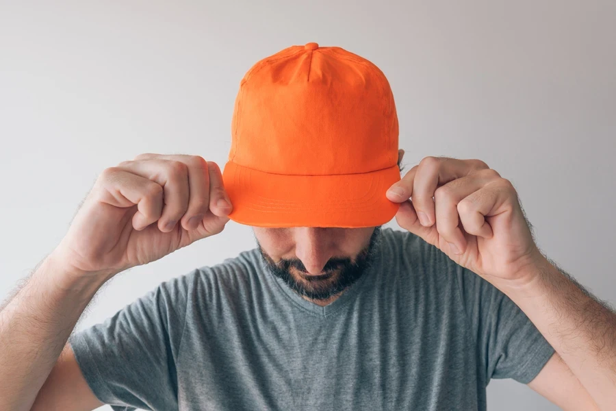 Hombre joven con sombrero naranja