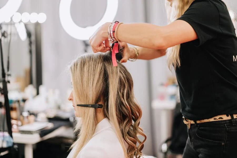 Un estilista arreglando el cabello de un cliente.