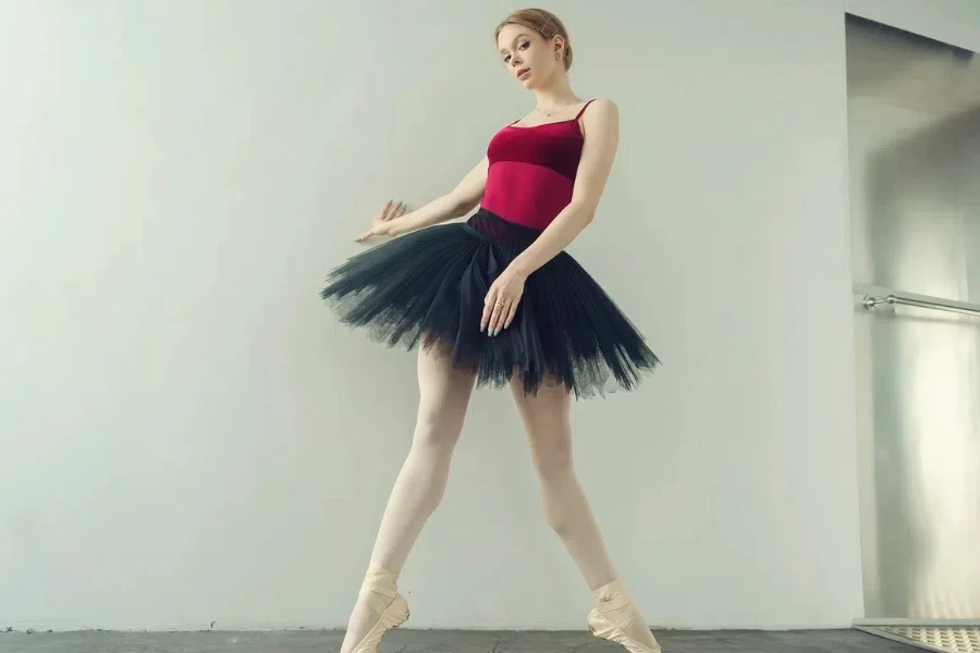 Beautiful ballerina in a red bodysuit, tutu, and pointe shoes