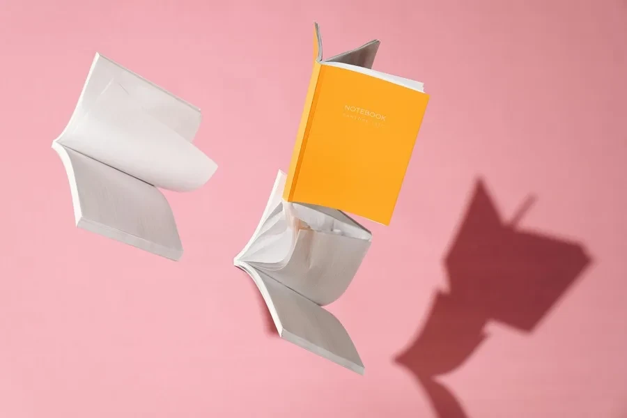 Books flying around a pink wall