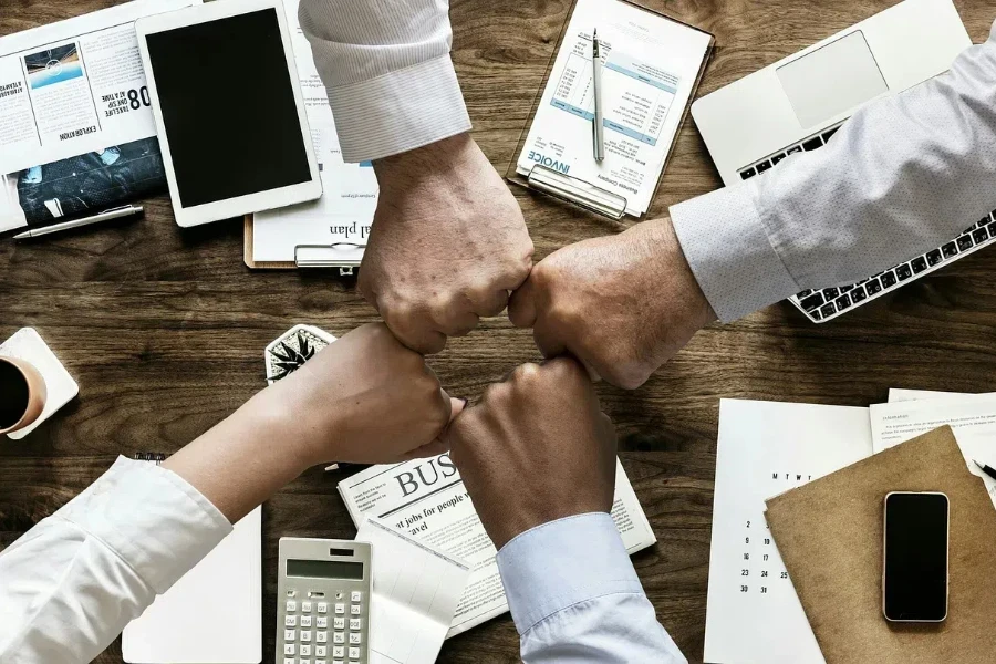 Business people bumping fists over documents