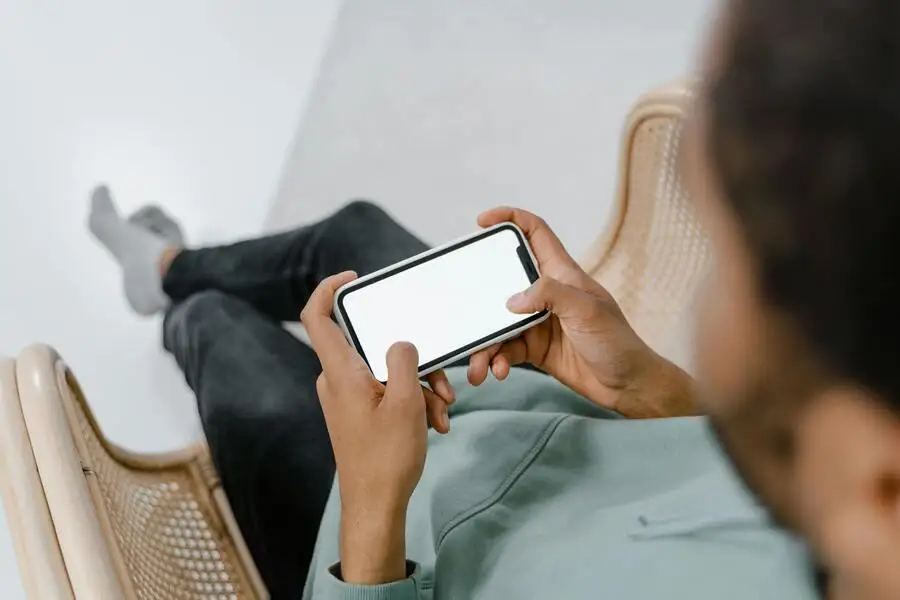 person holding a phone with a white case and screen