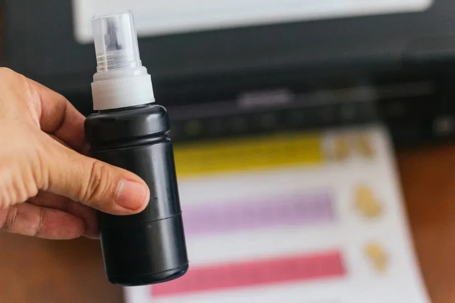 Person holding a tube of ink for tank printer