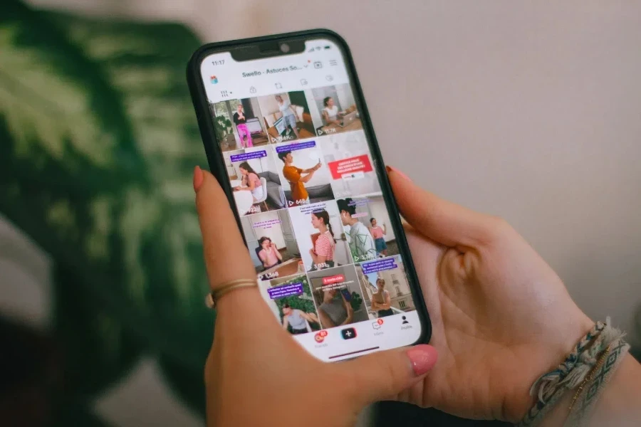 Человек держит телефон и прокручивает ленту TikTok