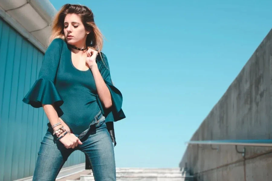 Woman in green bodysuit and jeans