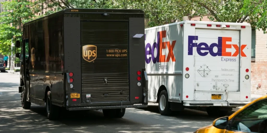 A UPS and FedEx delivery truck, side by side