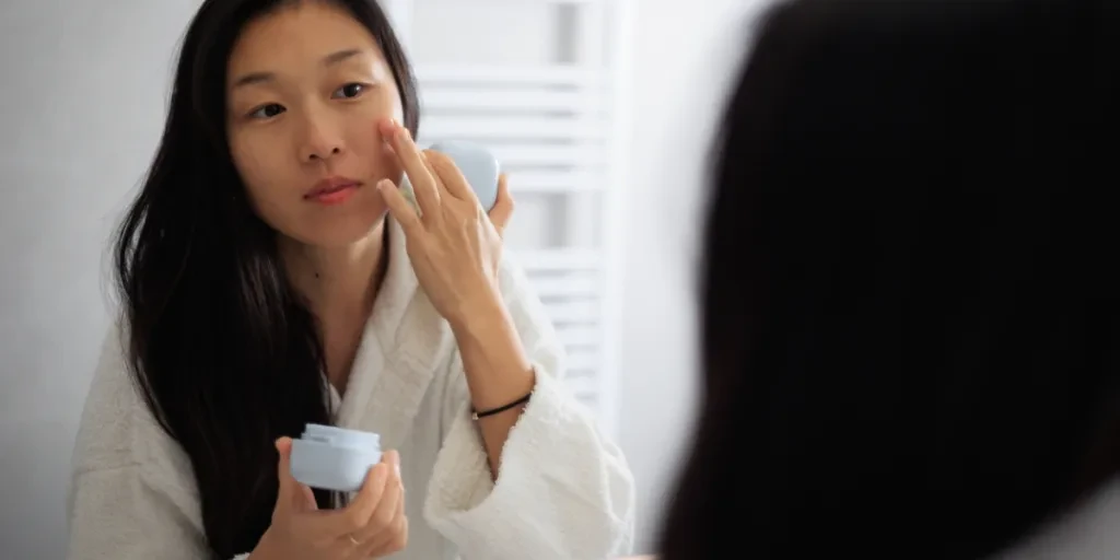 Uma linda mulher usando produtos para a pele